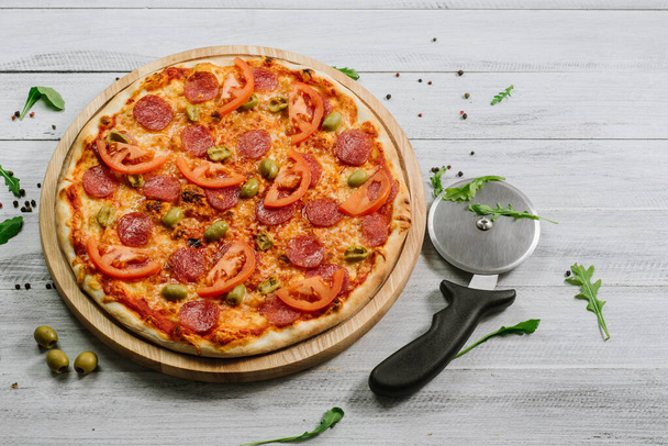 Delicious pizza Neapolitana with tomato sauce, mozzarella and ham on the white wooden background - Fotó, kép