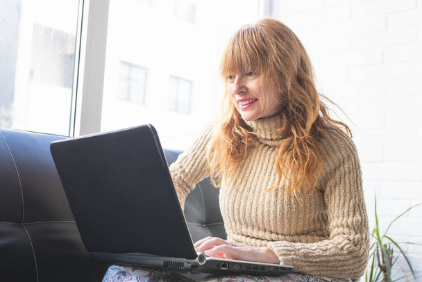 mulher adulta com laptop em casa
 - Foto, Imagem