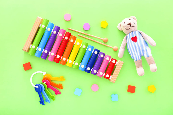 Colorful kids toys on green background. Top view, copy space - Photo, Image