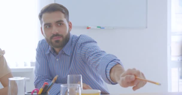 Jeune homme d'affaires de chemise qui réussit donne un crayon à un collègue lors d'une conférence
 - Séquence, vidéo