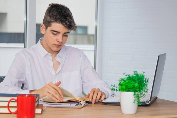 молодий студент підліток вдома або коледжі столу з книгами і комп'ютером
 - Фото, зображення