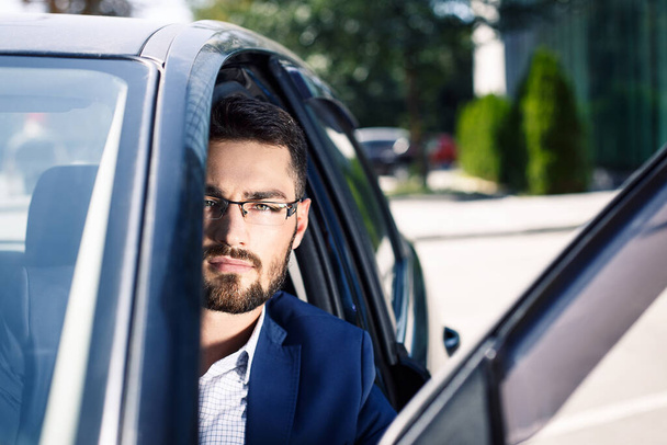 Nahaufnahme Porträt eines ernsthaften Mannes mit Brille und Sitz im Auto - Foto, Bild