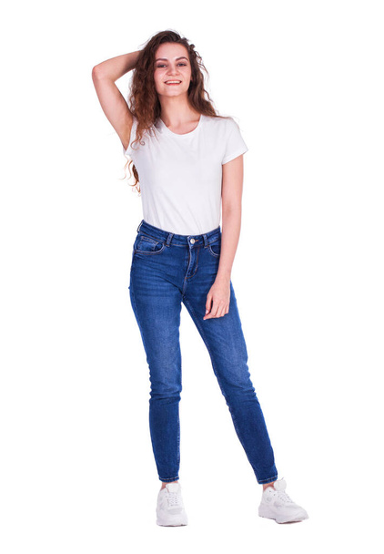 Full body portrait of a young beautiful brunette model in blue jeans, isolated on white background - Photo, image