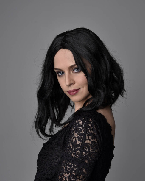 Nahaufnahme Porträt eines hübschen, gotischen Mädchens mit dunklen Haaren, das vor Studiohintergrund posiert. - Foto, Bild