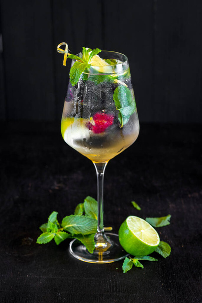 Fresh cold cocktail with lime and cherry on black background - Foto, Imagem
