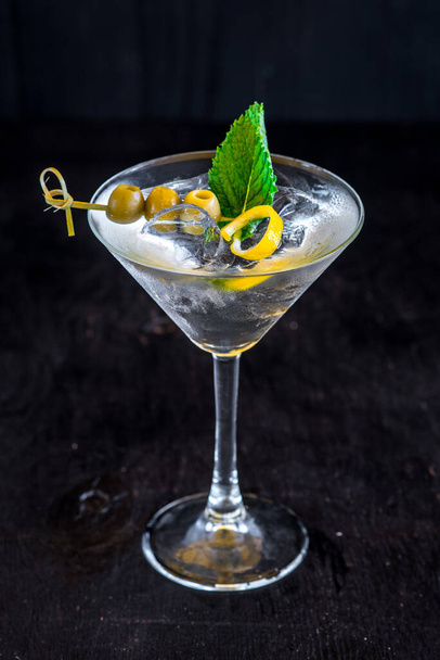 Cool transparent cocktail with olives on black background - Foto, Bild