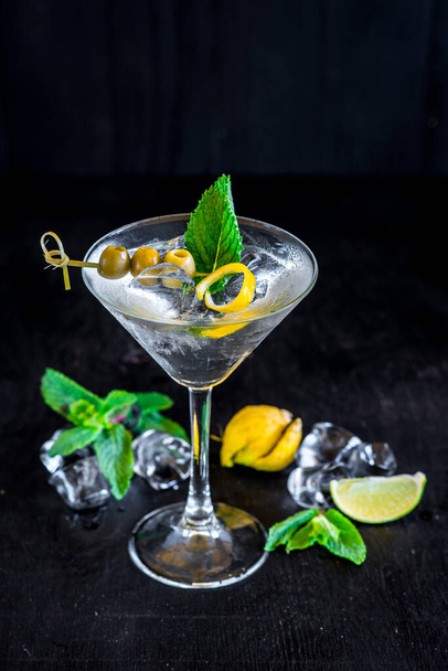 Cool transparent cocktail with olives on black background - Photo, image