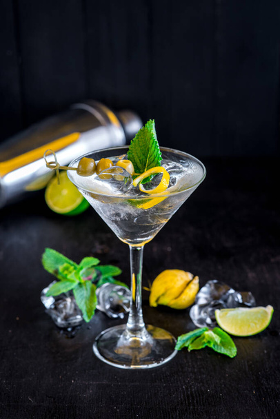 Cool transparent cocktail with olives on black background - Фото, изображение