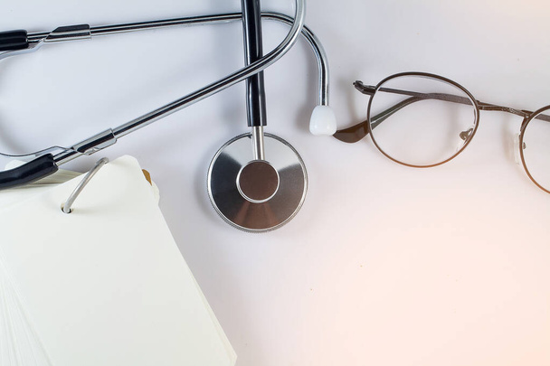Medical Headphones or earphone for doctor, various paper page notebook and glasses on white background and empty space - Φωτογραφία, εικόνα