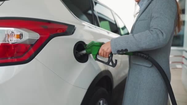 Woman fills petrol into her car at a gas station - Footage, Video