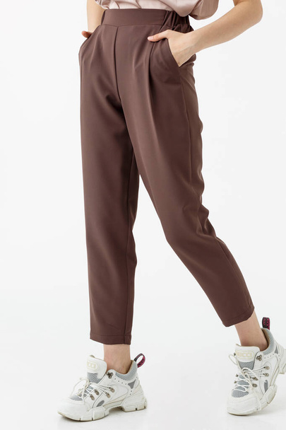 young girl in brown pants on white background - Fotó, kép