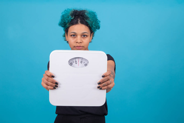 woman smiling with weight scale isolated on color background - Фото, изображение