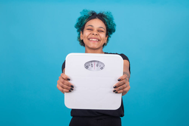 γυναίκα χαμογελώντας με κλίμακα βάρους που απομονώνονται στο φόντο χρώμα - Φωτογραφία, εικόνα