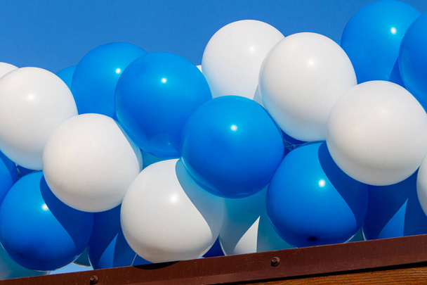 Mavi ve beyaz şişme balonların şenlikli arka planı. Şenlikli plastik hava şişirilebilir helyum balonları mavi doku arka planı. - Fotoğraf, Görsel