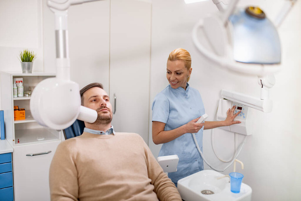 Tandarts voor te bereiden om tand x-ray beeld te maken voor de patiënt in de tandheelkundige kliniek.People, geneeskunde, stomatologie en gezondheidszorg concept. - Foto, afbeelding