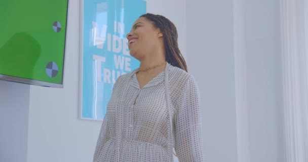 Menina africana com dreadlocks mostra uma apresentação no escritório fala risos alegria sucesso piada conversa
 - Filmagem, Vídeo