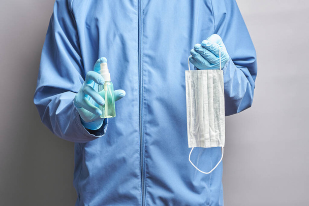 doctor holds a medical mask and a sanitizer - Zdjęcie, obraz