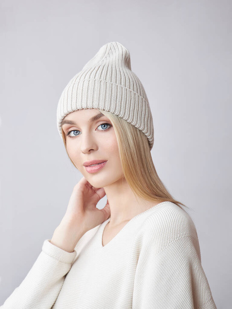 Blonde woman with long hair wearing a hat and a white sweater. Beauty portrait of a girl, natural cosmetics - Foto, Bild