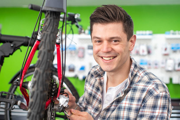 Portrait Of Male Small Business Owner Repairing Gears In Bicycle Repair Shop - Foto, afbeelding