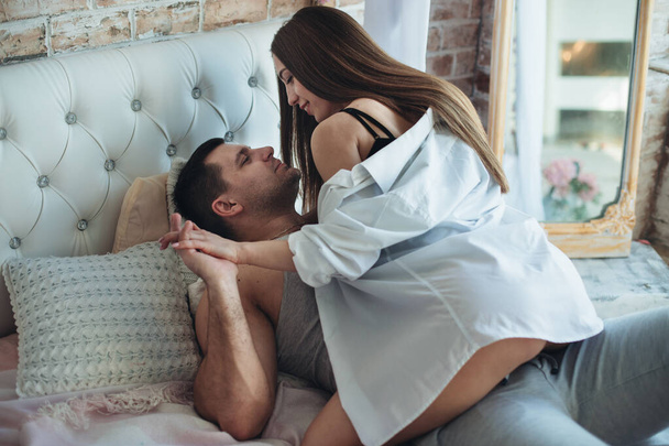Genç aşıklar erkek ve kadın yataktaki yataktalar. Sarıl, öp.. - Fotoğraf, Görsel