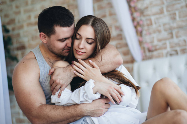 Jovens amantes homem e mulher no quarto na cama. Abraço, beijo
. - Foto, Imagem
