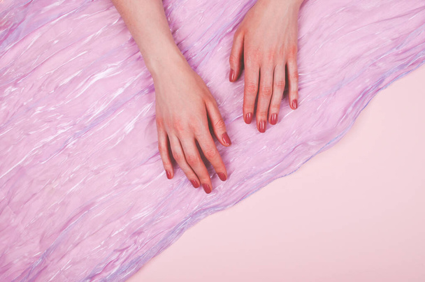 Woman hands with manicure and satin - Foto, Imagen