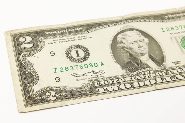 Twee dollar biljetten in contanten op witte achtergrond - Foto, afbeelding