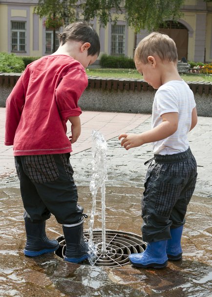 Діти грають з водяним фонтаном
 - Фото, зображення