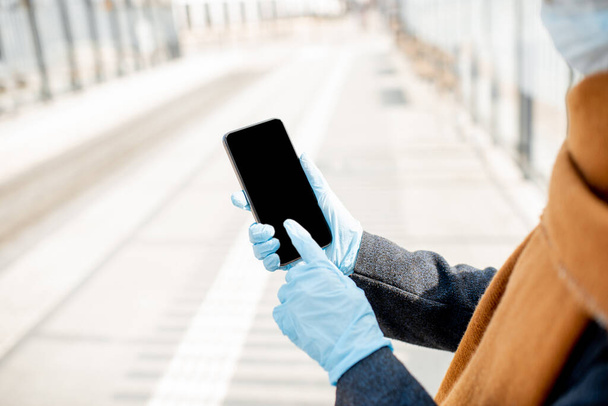Woman in medical gloves using smart phone outdoors - Foto, Imagem