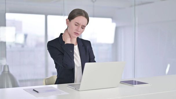 Fleißige junge Geschäftsfrau mit Nackenschmerzen im Büro - Foto, Bild