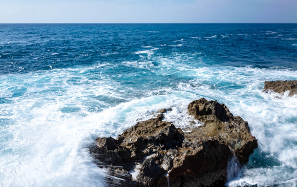 Waves crash on the rocky shore of the Mediterranean Sea on the Akamas Peninsula in the northwest of the island of Cyprus. - Foto, Imagen