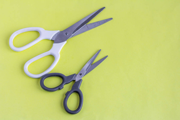 Nůžky na žlutém pozadí.Bílé velké a černé malé nůžky pro práci a kreativitu. - Fotografie, Obrázek
