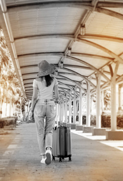 O fundo de design de arte abstrata da mulher arrastando bagagem para viajar, andando de lado, tom preto e branco, luz embaçada ao redor
 - Foto, Imagem