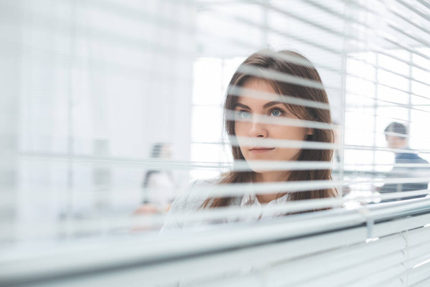 young business woman looking through office window - Fotoğraf, Görsel
