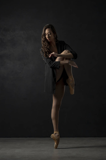 ballerina dancer dancing on the toes indoor with balck background - Photo, image