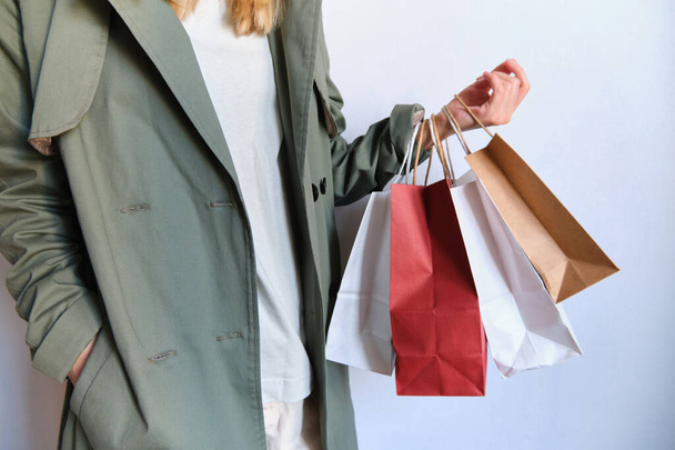 Happy woman holding in hand shopping package. Paper bag. Sale in store. Beautiful young girl in fashion shop. Customer buy present. Black friday sale. Holiday special offer, discount. Female in market - Foto, Imagen
