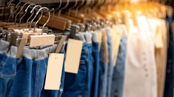 Jeans oder Jeanshosen (Hosen), die an einem Kleiderständer im Bekleidungsgeschäft hängen. Modekollektion im Bekleidungsgeschäft zum Verkauf. Textilindustrie und Geschäftskonzept - Foto, Bild