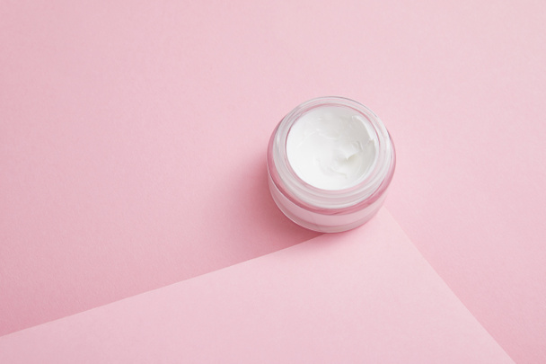 Cosmetic cream in glass jar on pink background  - Valokuva, kuva