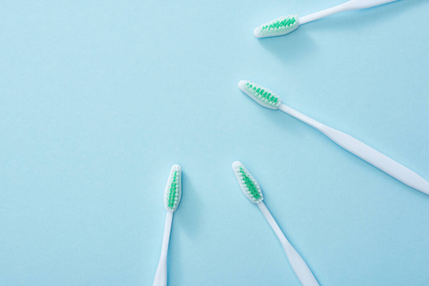 Top view of white toothbrushes on blue background - Fotoğraf, Görsel