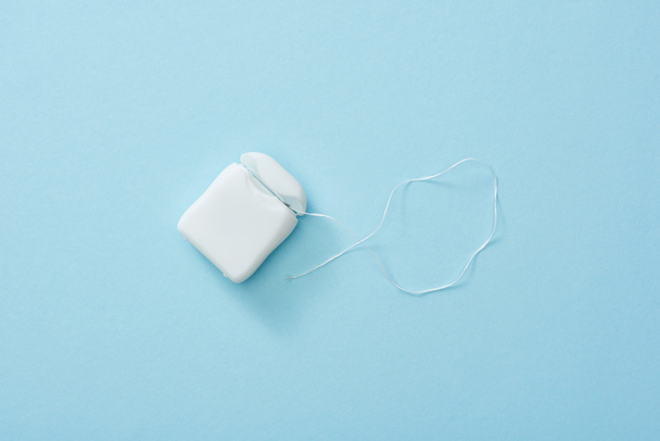 Top view of white dental floss on blue background - Фото, изображение