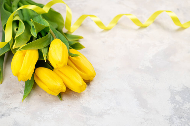 Żółte tulipany na pastelowym tle widok z góry. Wesołych wakacji. Dzień matki, Wielkanoc, Walentynki, Dzień matki, Koncepcja ślubna. Świąteczna kartka, zaproszenie, baner. Przestrzeń kopiowania - Zdjęcie, obraz