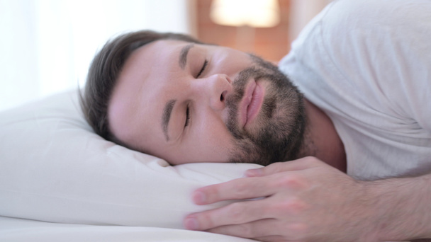 Közel a szakállas fiatalember alszik az ágyban - Fotó, kép