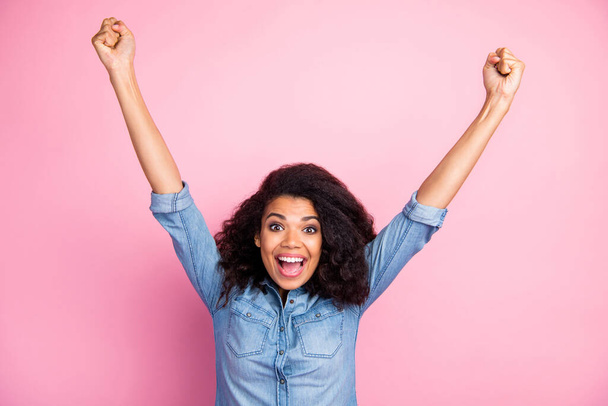 Portrait of crazy funky afro american girl hear unbelievable lottery win news impressed scream wow omg raise fists wear casual style clothing isolated over pink color background - Foto, imagen