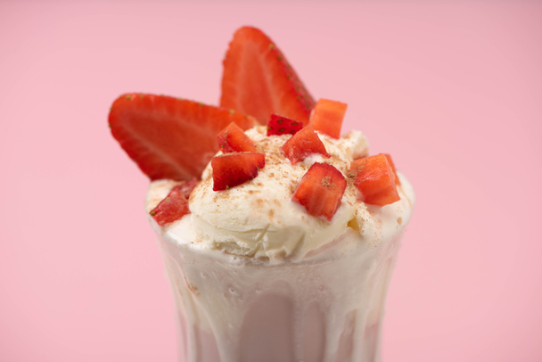 Selective focus of glass of milkshake with ice cream and strawberries isolated on pink - Foto, Imagen
