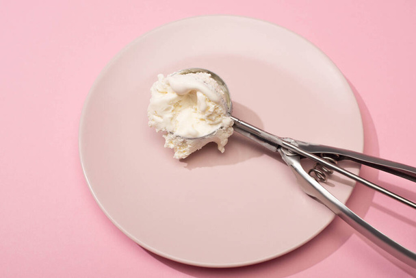 Hochwinkelblick auf Schaufel mit Eis auf Teller auf rosa - Foto, Bild