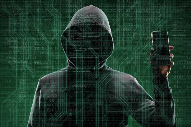 Anonymous computer hacker with a smartphone over abstract digital background. Obscured dark face in mask and hood. Data thief, internet attack, darknet fraud, dangerous viruses and cyber security concept. - Valokuva, kuva