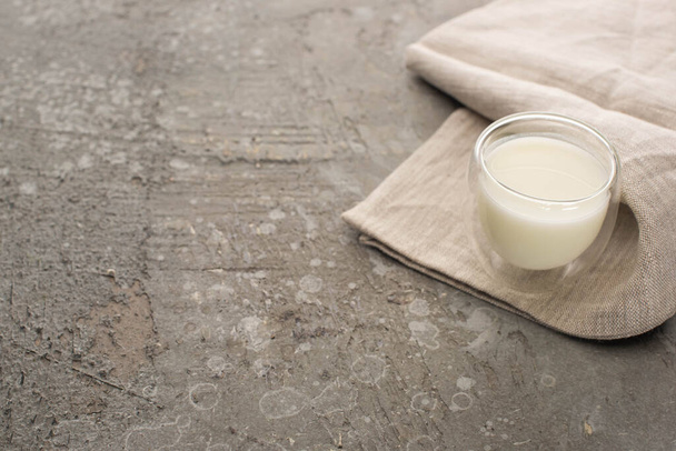 Vista de alto ángulo del vaso de yogur casero sobre tela beige sobre fondo gris
 - Foto, Imagen