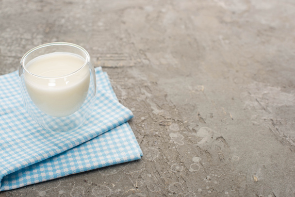 High angle view of glass of homemade yogurt on plaid cloth on grey background - Foto, afbeelding