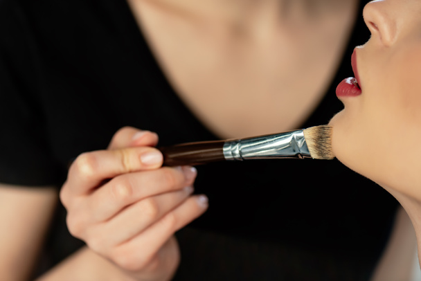 cropped view of young makeup artist applying concealer on model  - Fotografie, Obrázek