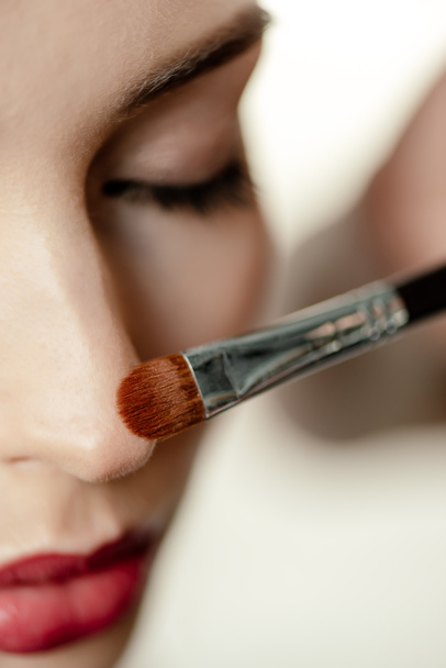 selective focus of cosmetic brush near woman with closed eyes  - Foto, Imagem